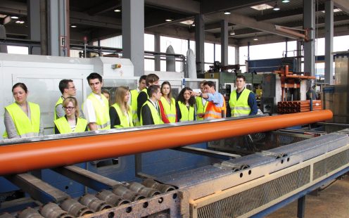 People watching how plastic pipes are produced at production site of Pipelife